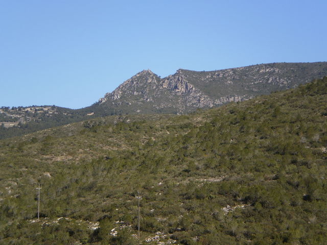 Südanfahrt: Das ist das Kernstück der Serra de Montmell. Man erkennt das Castell de Montmell auf der Bergspitze und die Kirche Sant Miquel links darunter. Noch weiter nach rechts liegt der Puig de la Talaia (nicht mehr im Bild).