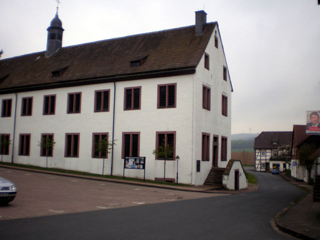 Kloster Falkenhagen mit Köterberg im Hintergrund und einem grinsenden Landtagskandidaten in Papierform.