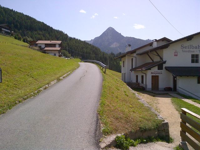 Die Straße beim Passieren der Bergstation der Seilbahn Verdins - Tall.