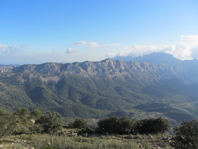 Die sägezahnartige Serra del Ferrer von oben. Der bewölkte Berg dahinter gehört zur Serra de Bernía.