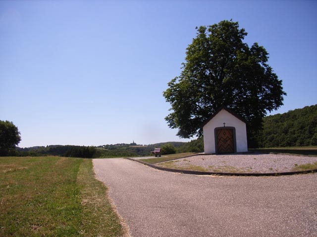 Die Kapelle „Auf Seligen” mit dem Kirchturm von Wald im Hintergrund.