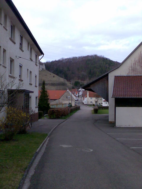 Blick durch Hütten im Hintergrund die Auffahrt nach Justingen .