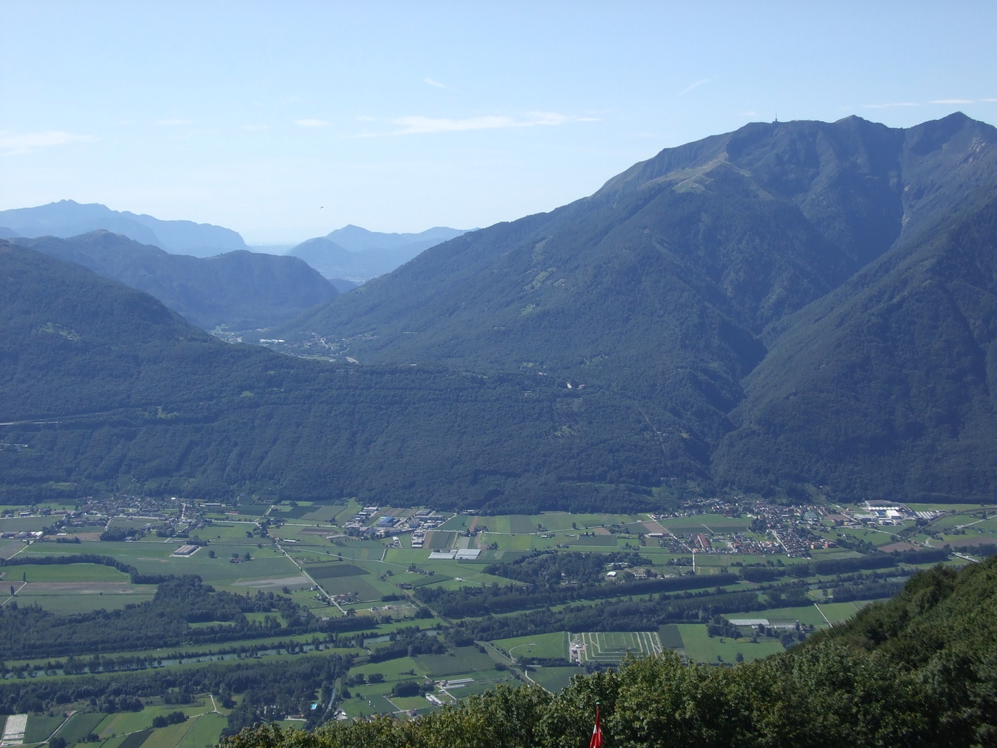 Die Magadino-Ebene mit dem Einschnitt des Passo Monte Cèneri und dem Monte Tamaro rechts daneben.