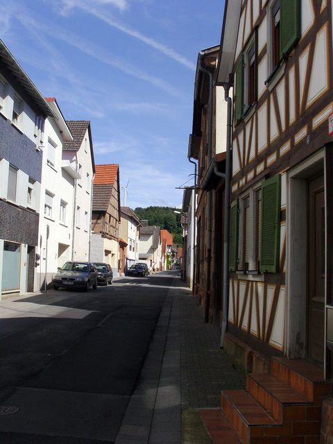 Raibach Ortsdurchfahrt mit Windrad im Hintergrund.
