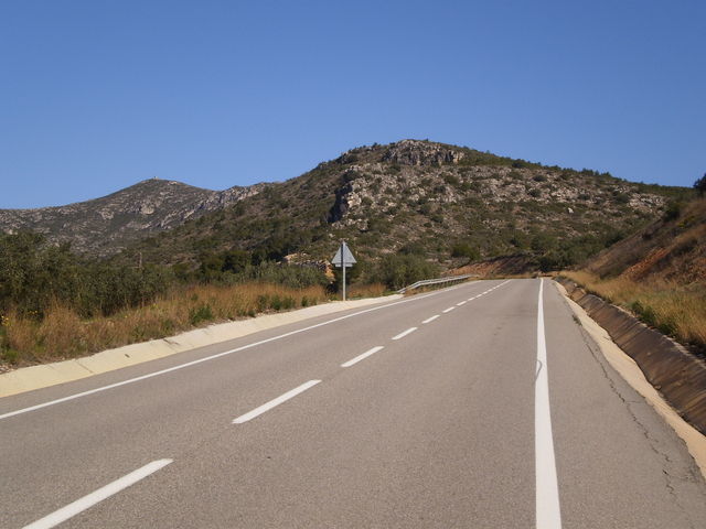 Südanfahrt: Breite Straße erstmal, vorne im Bild der Puig del Coscollar, dahinter der Puig de la Cova.