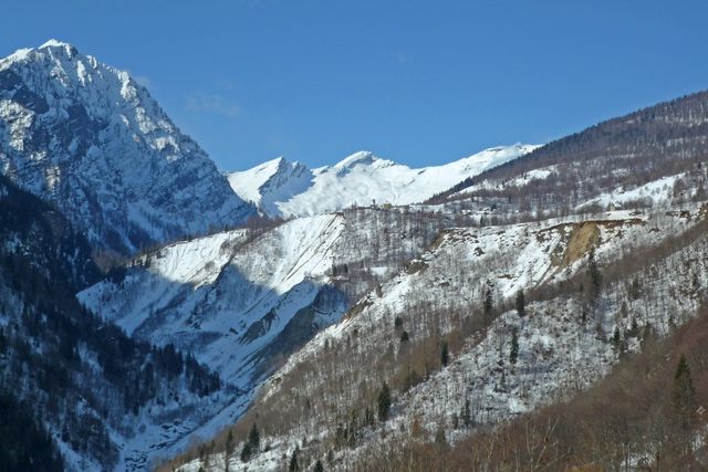 11 man sieht die abrutschende Hänge unterhalb von Cimalmotto, hinten P. Quadro (2792m) und Madone o Batnall (2748m), 20.3.09.
