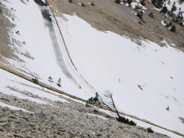 Verschneite Abfahrt nach Malaucène: Ein Rennradfahrer kämpft sich über die verschneite Fahrbahn.