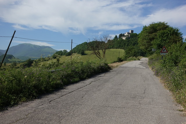 Auf der SP272 kommt in Fahrtrichtung ein Hügel mit Turm in Sicht. Der Name der Burg ist uns unbekannt.