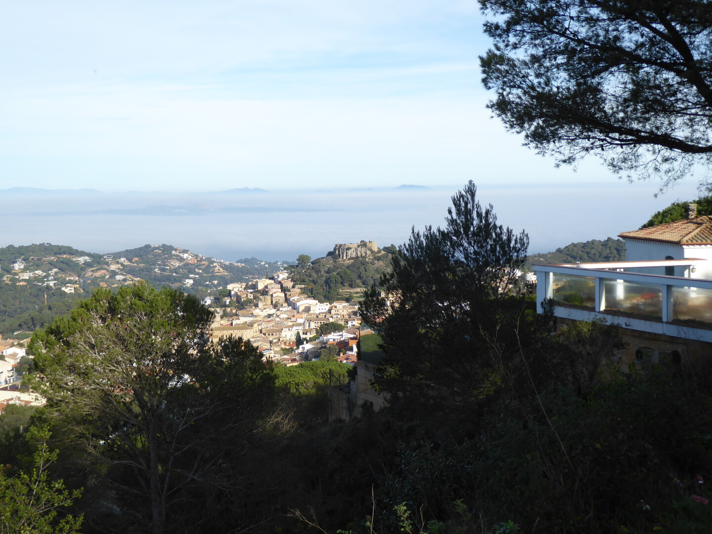 Blick von oben auf Begur und das Cap de Creus. Ohne Nebel wäre auch Wasser zu sehen.
