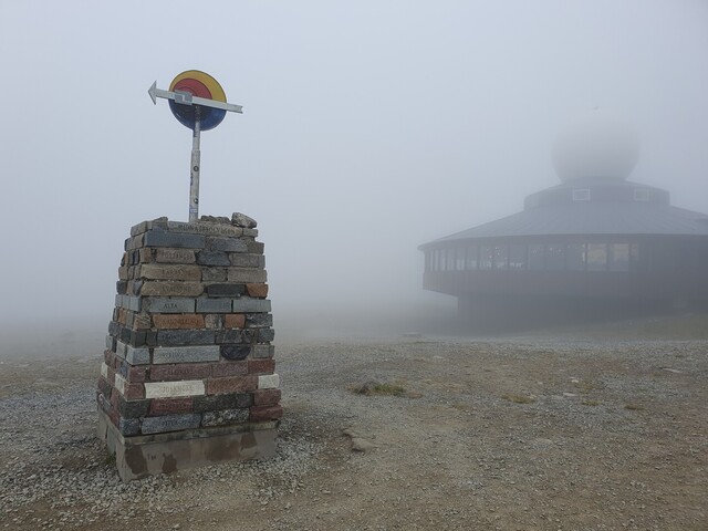 Das Mitternachtssonnen-Denkmal und die Nordkaphalle im Nebel