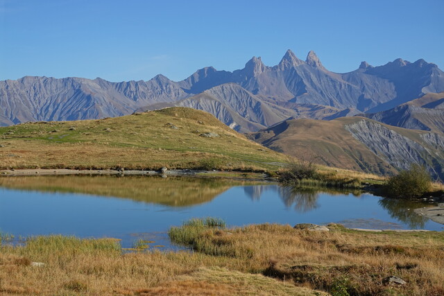 Die Aiguilles spiegeln sich im glasklaren Wasser des Bergsees.