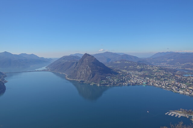 Aussicht vom Panoramarestaurant auf den Lago di Lugano mit dem dich spiegelnden Monte San Salvatore.